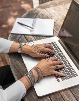person typing on MacBook Pro on brown wooden table during daytime photo