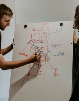 man drawing on dry-erase board