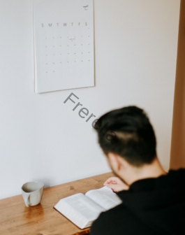 a man sitting at a desk with an open book