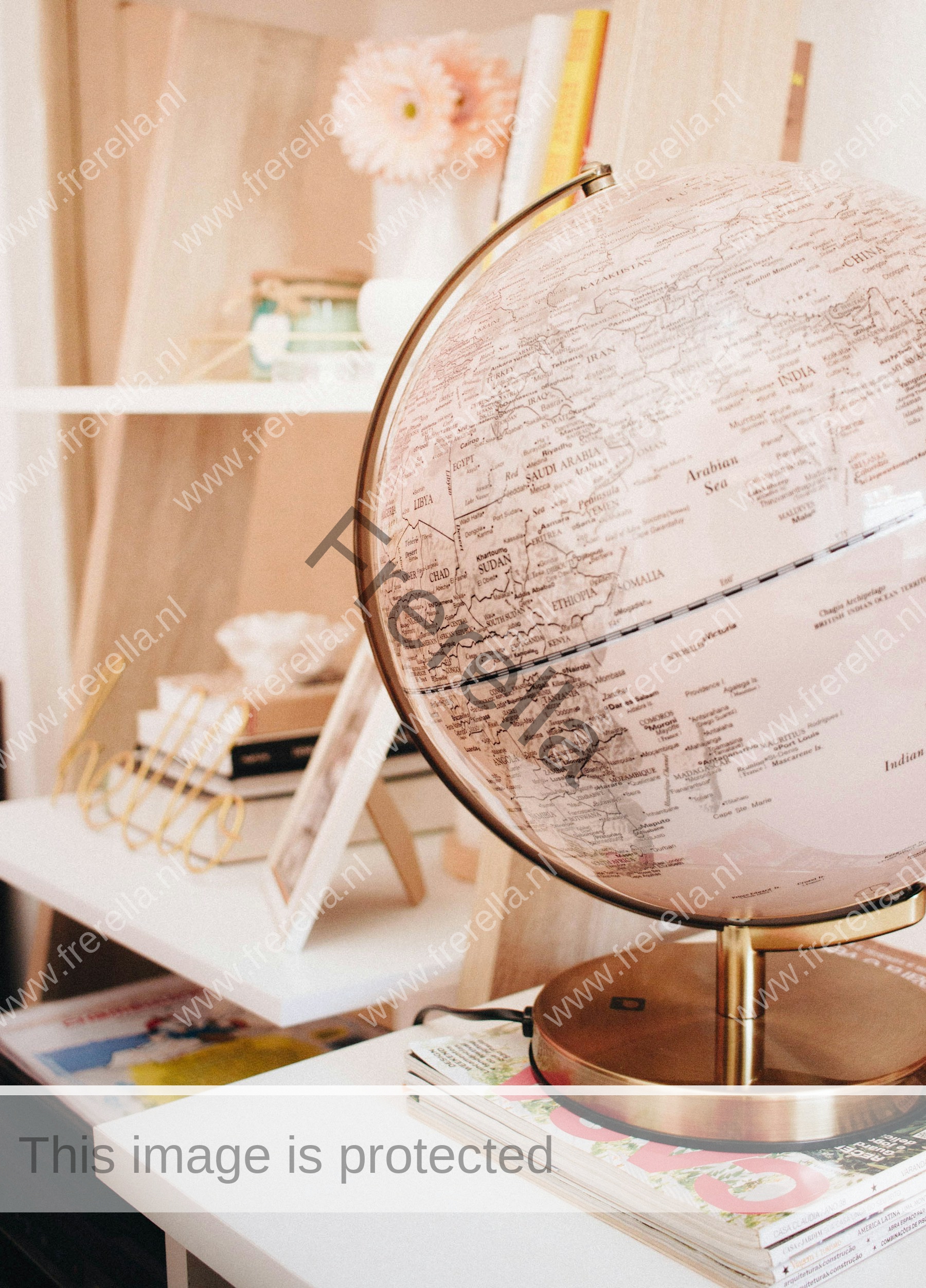 white and black desk globe on the top of magazines