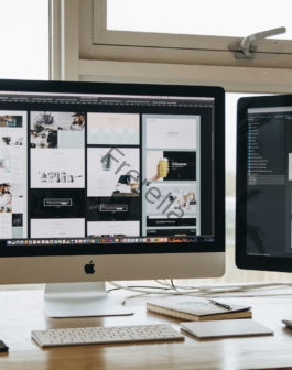 Two monitors setup next to each other on a computer desk.
