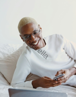 man in white turtleneck sweater holding smartphone