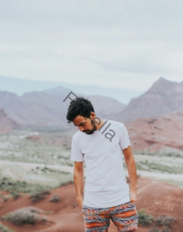 man wearing white crew-neck shirt across mountain