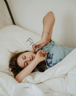 woman covered in white blanket sleeping on white bed comforter