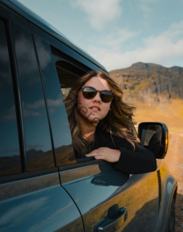 a woman wearing sunglasses leaning out of a car window