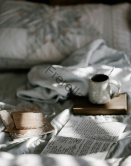 coffee mug on a brown wooden coaster near white blanket