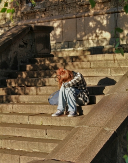 woman in black and white dress sitting on concrete stairs