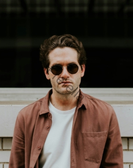 man standing in front of white concrete wall