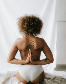 woman kneeling with both hands on her back doing praying gesture
